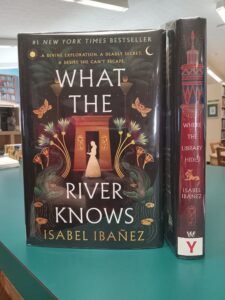 Book cover for 'What The River Knows', and book spine for 'What the Library Hides'