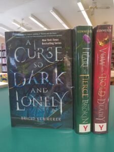 Book cover for 'A Curse so Dark and Lonely' and book spines for 'A Heart so Fierce and Broken' and 'A Vow so Bold and Deadly'