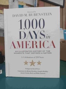 Cover for '1,000 Days in America: An Illustrated History of the Moments the Defined a Nation', with a white cover and red and blue text