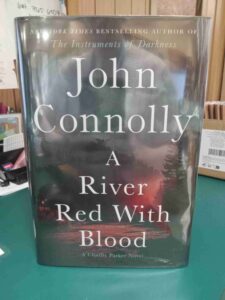 Cover for the novel 'A River Red with Blood', featuring a photo of a river at night, with that makes the river glow red