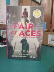 Cover for the Novel 'Pair of Aces', with a photo of one woman walking into and one woman walking away from a courthouse
