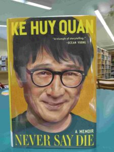 Photo of the cover for the memoir 'Never Say Die', featuring an illustration of Ke Huy Quan's face